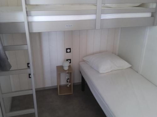 Cette petite chambre comprend 2 lits superposés et une table. dans l'établissement Chalet 3 chambres, piscine, lac à 100m - Olonzac - FR-1-783-1, à Olonzac