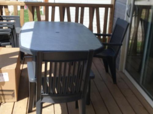 - une table noire et 2 chaises sur une terrasse couverte dans l'établissement Chalet tranquille en Bretagne avec piscine chauffée, 2 chambres, proche mer et nature - FR-1-783-15, à Arzal