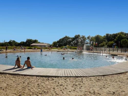 - un groupe de personnes dans une piscine sur la plage dans l'établissement Chalet 2 chambres au calme avec terrasse, piscine chauffée et accès lac en Vendée - FR-1-783-26, à La Chapelle-Hermier