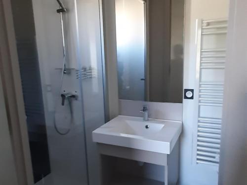 a white bathroom with a sink and a shower at Chalet confort 3 chambres, piscine chauffée, entre mer et nature près du Golfe du Morbihan - FR-1-783-3 in Marzan