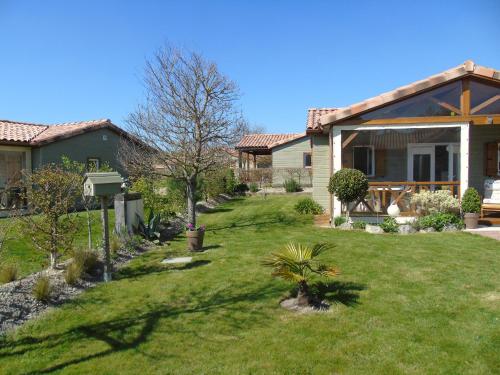 une maison avec une cour dotée d'une pelouse sidx sidx sidx dans l'établissement Chalet 2 chambres au calme avec piscine chauffée, proche lac et plages en Vendée - FR-1-783-20, à La Chapelle-Hermier