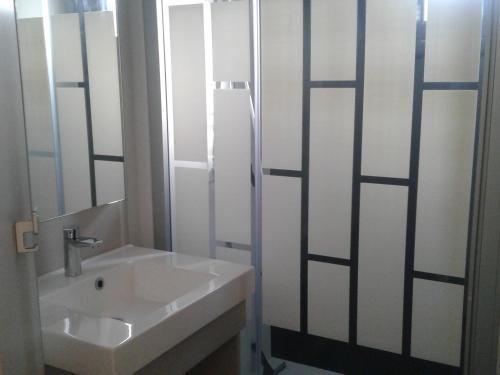 een badkamer met een wastafel en een douche met een spiegel bij Chalet Guérande, 3 pièces, 4 personnes - FR-1-783-17 in Guérande