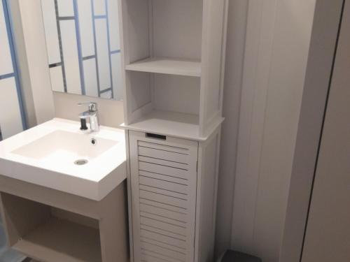 a white bathroom with a sink and a mirror at Charmant Chalet 3 Chambres avec Piscine Couverte à 10 min de la Plage de La Baule - FR-1-783-18 in Guérande
