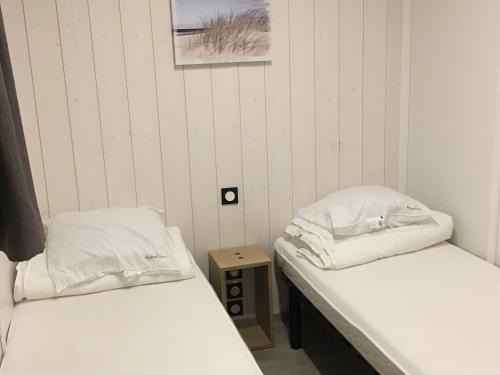 two beds in a room with white walls at Chalet 3 chb, 2 sde, domaine sécurisé avec piscine chauffée, proche plages Méditerranée - FR-1-783-22 in Pomérols