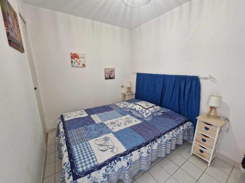 ein kleines Schlafzimmer mit einem Bett und einem blauen Vorhang in der Unterkunft Appartement Marseillan-Plage, 2 pièces, 4 personnes - FR-1-326-815 in Marseillan
