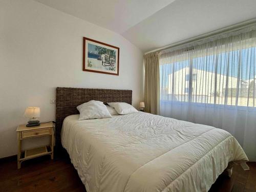 une chambre avec un grand lit et une fenêtre dans l'établissement Maison à La Cotinière, 6 couchages, proche port et plage, jardin, terrasse, parking privé - FR-1-246A-293, à Saint-Pierre-dʼOléron