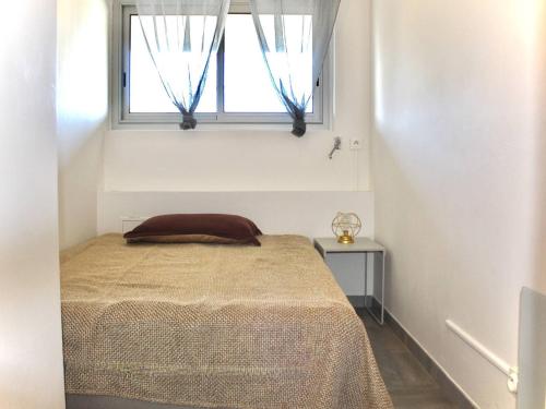 un lit dans une chambre avec une fenêtre dans l'établissement Appartement moderne 2 Pièces RDC, climatisé avec terrasse, proche commerces, 4 couchages - FR-1-252A-118, à Villeneuve-Loubet