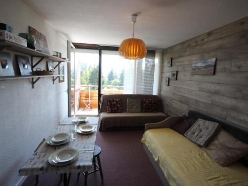 a living room with a couch and a table at Studio Chamrousse, 1 pièce, 4 personnes - FR-1-549-138 in Chamrousse
