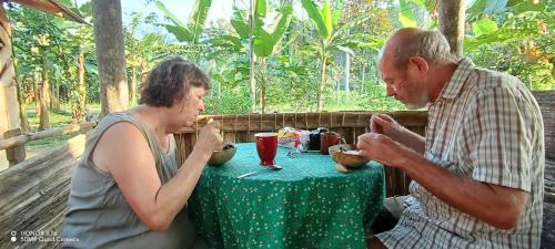 Ein Mann und eine Frau sitzen an einem Tisch in der Unterkunft Lodging and adventures in Soposo