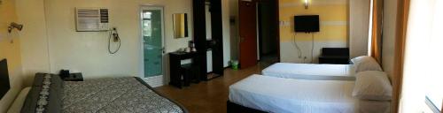 a hotel room with two beds and a television at Metro Park Hotel Mandaue in Cebu City