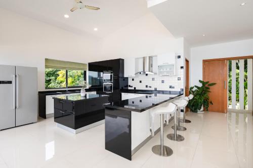 a kitchen with black and white counters and stools at Karpe Diem Villa - Twin Infinity Pools in Chaweng Noi Beach