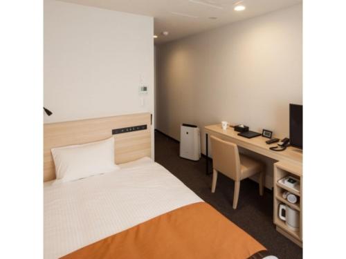 Cette chambre comprend un lit et un bureau avec un ordinateur. dans l'établissement Y's Hotel Asahikawa Ekimae - Vacation STAY 65443v, à Asahikawa