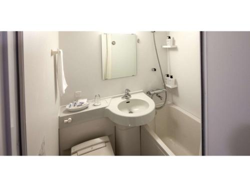 La salle de bains est pourvue d'un lavabo, de toilettes et d'un miroir. dans l'établissement Y's Hotel Asahikawa Ekimae - Vacation STAY 65443v, à Asahikawa