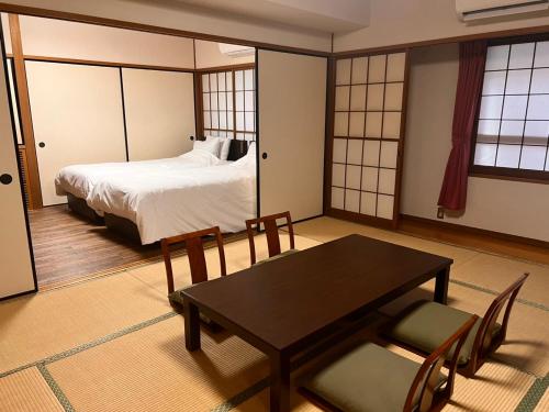 静岡市にある弘法の湯　長岡店のベッドルーム1室(ベッド1台、テーブル、椅子付)