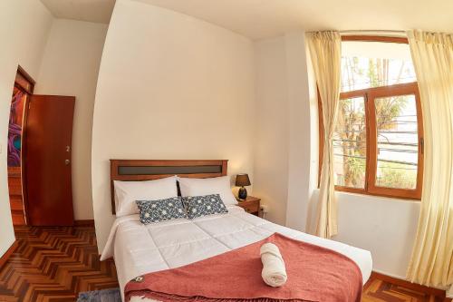 a bedroom with a large bed with a window at SILLARY HOSTAL Sede Cayma in Arequipa