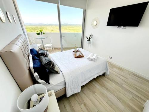 una camera da letto con un letto e una grande finestra di Ecusuites Karibao Room 2 preference con Balcón Vista al Mar a Playas