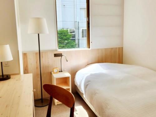 a bedroom with a bed and a chair and a window at Shin-Osaka Station Hotel in Osaka