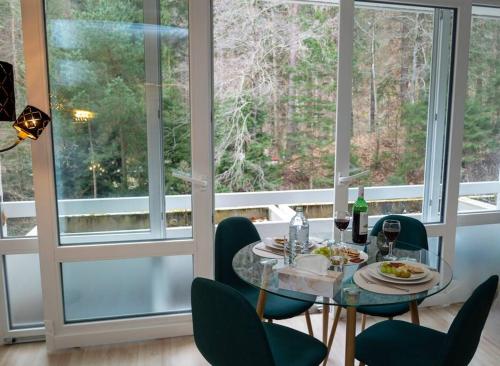 Apartment am Ossiachersee mit eigenem Seezugang في Landskron: غرفة طعام مع طاولة وكراسي زجاجية