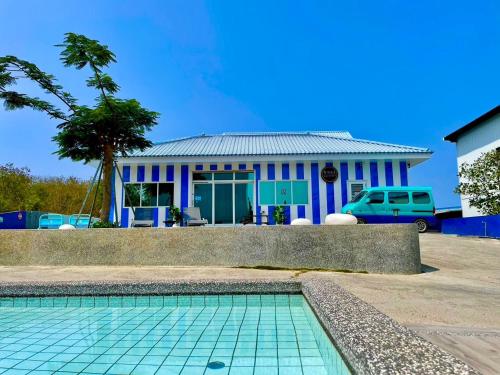 a house with a swimming pool in front of a house at Loju Seaview Homestay in Xiaoliuqiu