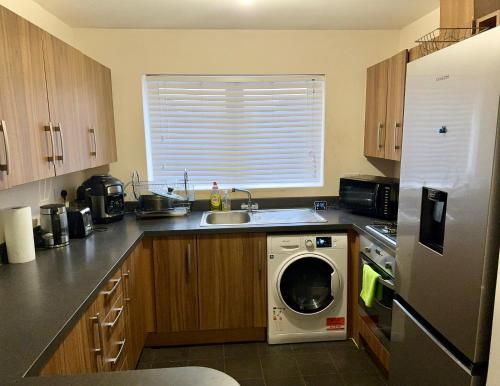 a kitchen with a washing machine in a kitchen at Comfortable double room with shared spaces in West Bromwich