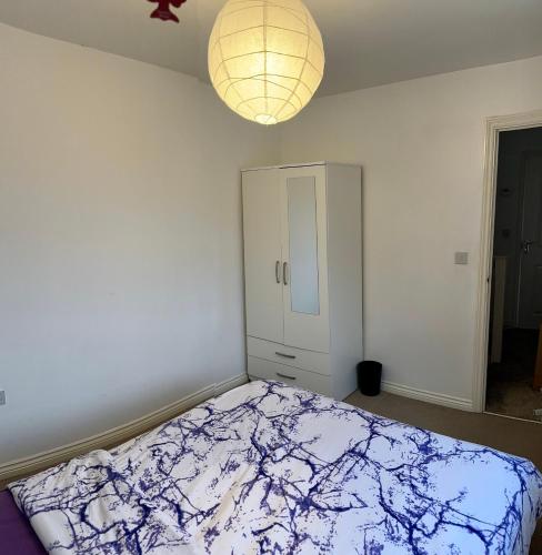 Schlafzimmer mit einem Bett und einem Kronleuchter in der Unterkunft Comfortable double room with shared spaces in West Bromwich