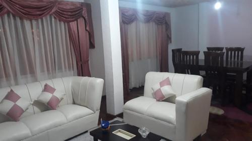 ein Wohnzimmer mit 2 weißen Sofas und einem Tisch in der Unterkunft Apartamento en Miraflores in La Paz