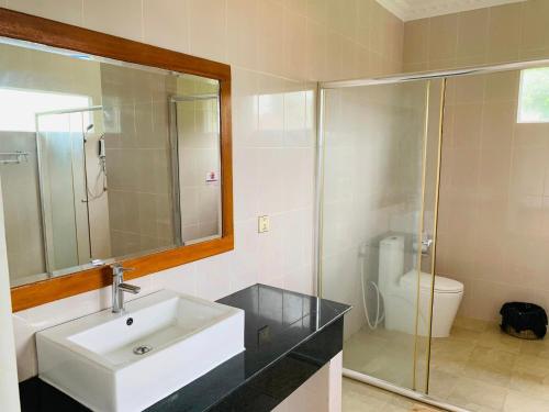 uma casa de banho com um lavatório e uma cabina de duche em vidro. em May Beach Resort em Koh Rong