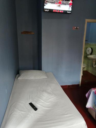 コマヤグアにあるHotel 24/7のベッド(リモコン付)が備わる客室です。