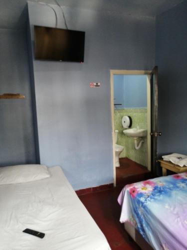 コマヤグアにあるHotel 24/7のベッドルーム1室(ベッド1台付)、バスルーム(シンク付)