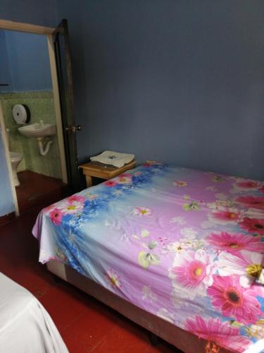 コマヤグアにあるHotel 24/7のベッドルーム1室(花の飾られたベッド1台付)