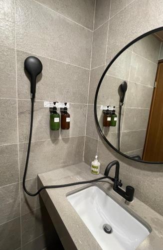 a bathroom with a sink and a round mirror at 在覺樂禪意文旅-訂房後須聯繫轉帳 in Tainan