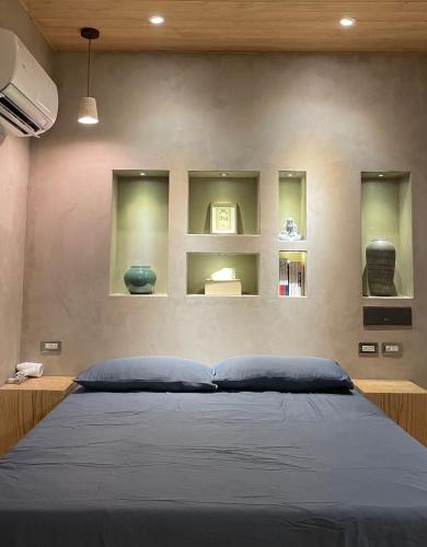 a bedroom with a bed and shelves on the wall at 在覺樂禪意文旅-訂房後須聯繫轉帳 in Tainan
