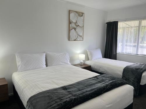 a bedroom with two beds and a window at Magnolia Court Motel in Opotiki