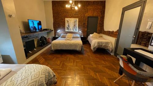 a hotel room with two beds and a tv at PH Palermo HollyHouse in Buenos Aires