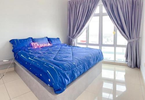 a bed with a blue comforter in a bedroom at Manhattan Austin By JC Home in Johor Bahru