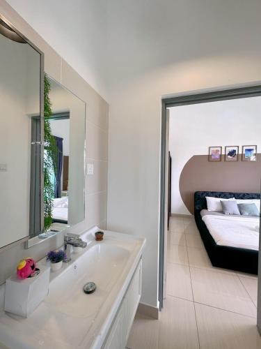 a bathroom with a sink and a bed with a mirror at Manhattan Austin By JC Home in Johor Bahru