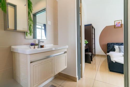 a bathroom with a sink and a mirror and a bed at Manhattan Austin By JC Home in Johor Bahru