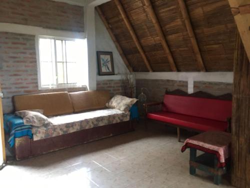 a living room with a couch and a red bench at Alquiler casa completa, Puerto Cayo, hermosa vista in Puerto Cayo
