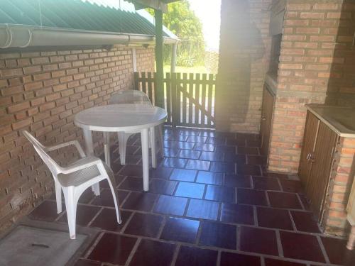 uma mesa branca e cadeiras num pátio de tijolos em Parada y relax en Alvorada, Barra do Chui em Xuí
