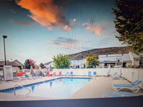 a large swimming pool with chairs at Bienvenue chez Alice et daniel in Saint-Férréol-les-Neiges