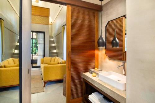烏布的住宿－Luxury 2BR Private Pool loft forest ZN54，一间带水槽和黄色沙发的浴室
