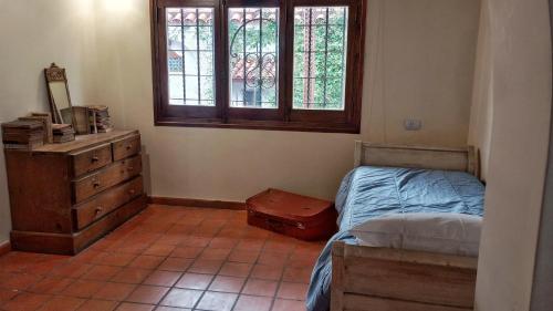 a bedroom with a bed and a dresser and a window at El Torreón Lodge in Potrerillos