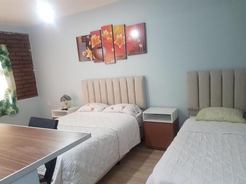 Habitación de hotel con 2 camas y mesa en Departamentos PEUQUE en Comodoro Rivadavia