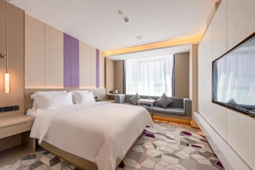 a hotel room with a bed and a television at Lavande Hotel Shenzhen Baoan International Convention and Exhibition Center in Shenzhen