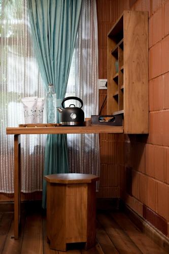 a table with a tea kettle on it next to a window at Little Chembaka in Kumarakom