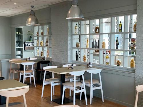 a restaurant with tables and chairs and shelves of wine bottles at Garner Hotel Maastricht by IHG in Maastricht