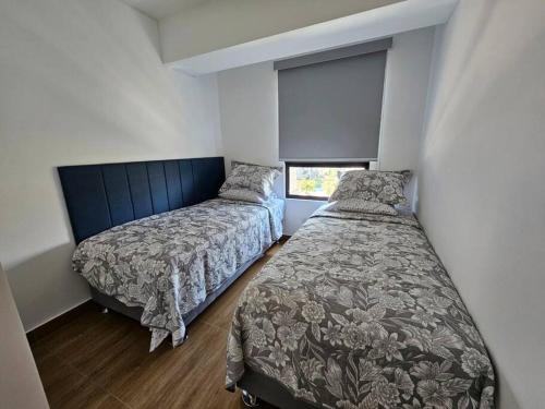 a bedroom with two beds and a window at De lujo y exclusivo, con estacionamiento in Lima