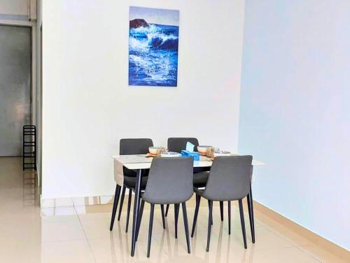 a dining room table with chairs and a painting on the wall at Bayu Temiang- Your Urban Retreat in Seremban
