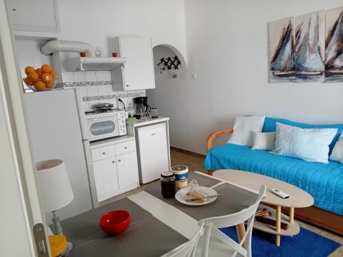 una pequeña cocina con mesa y sofá en Logaras Seaview Apartment en Logaras