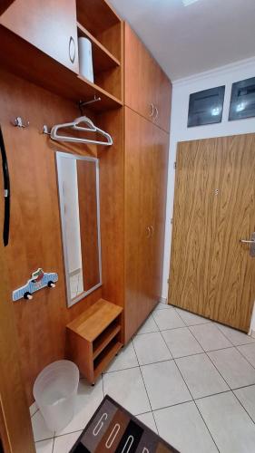 baño con espejo y puerta de madera en Sunny Apartman, en Siófok